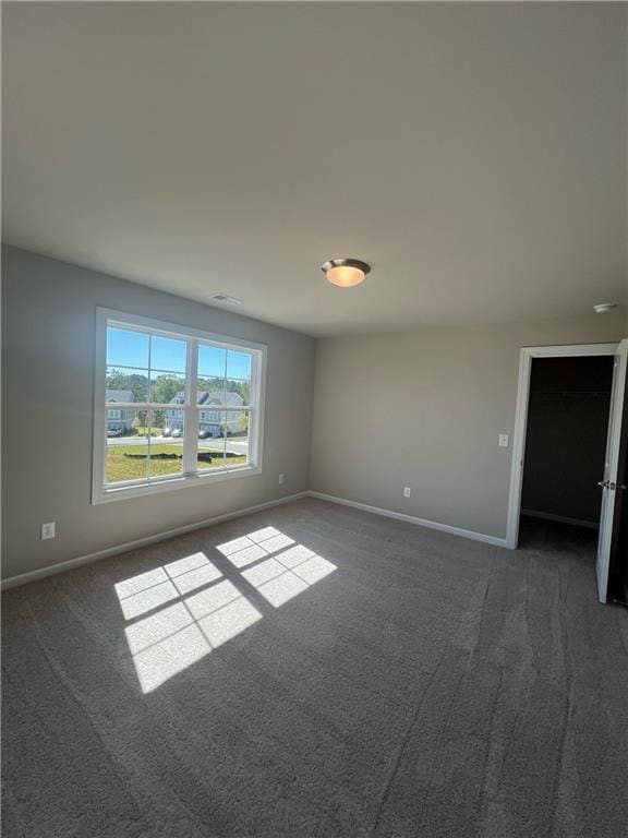 unfurnished room featuring dark carpet