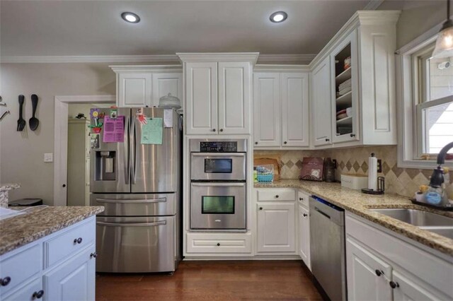 kitchen with dark wood finished floors, white cabinetry, a sink, and appliances with stainless steel finishes