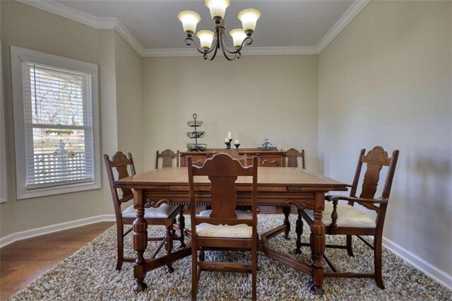 dining area featuring baseboards, crown molding, wood finished floors, and a chandelier