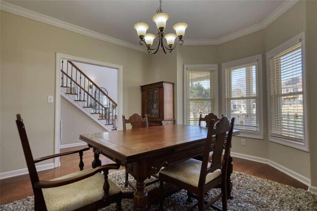 dining room with a notable chandelier, crown molding, and baseboards