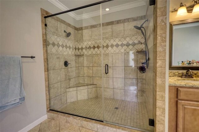 bathroom with crown molding, baseboards, tile patterned floors, vanity, and a stall shower
