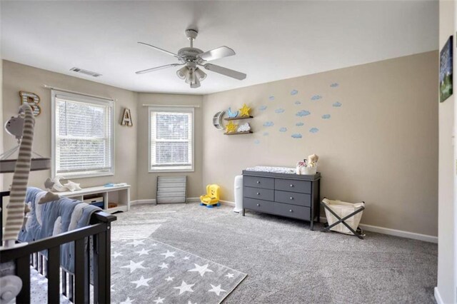 carpeted bedroom with a ceiling fan, baseboards, and visible vents