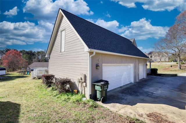 view of home's exterior featuring roof with shingles, a garage, and a yard