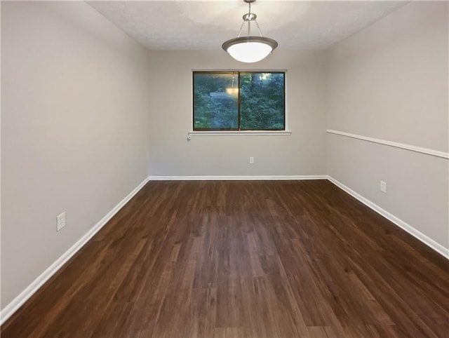 unfurnished room with wood finished floors and baseboards