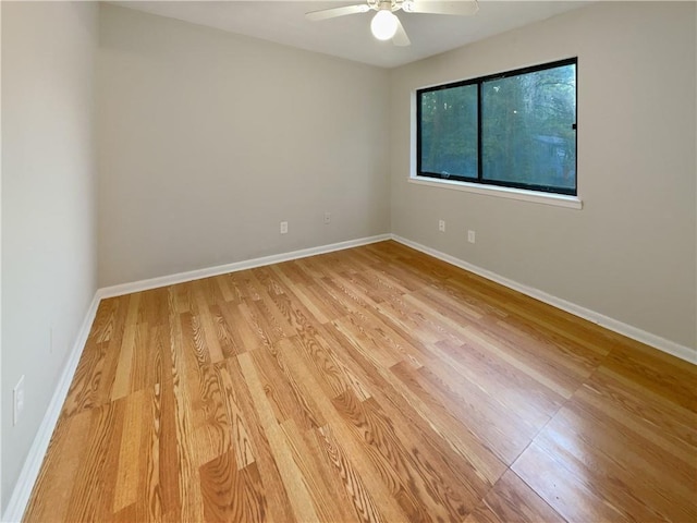 empty room featuring baseboards, ceiling fan, and light wood finished floors