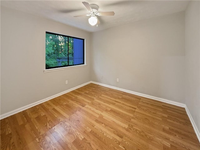 unfurnished room with light wood finished floors, ceiling fan, and baseboards