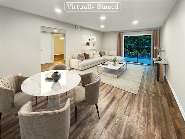 living room with recessed lighting, visible vents, baseboards, and wood finished floors