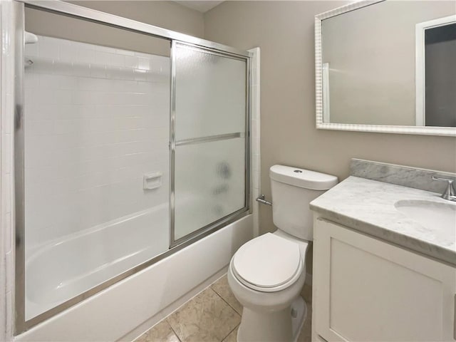 full bathroom featuring bath / shower combo with glass door, tile patterned flooring, vanity, and toilet