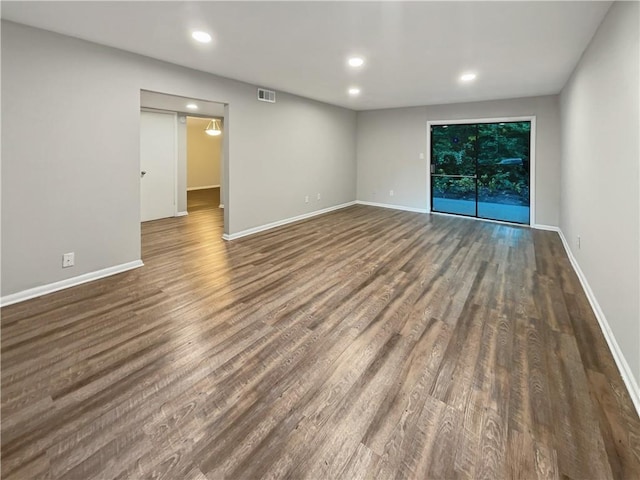 unfurnished room featuring recessed lighting, wood finished floors, visible vents, and baseboards