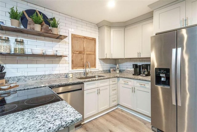 kitchen featuring light stone countertops, white cabinetry, sink, and appliances with stainless steel finishes