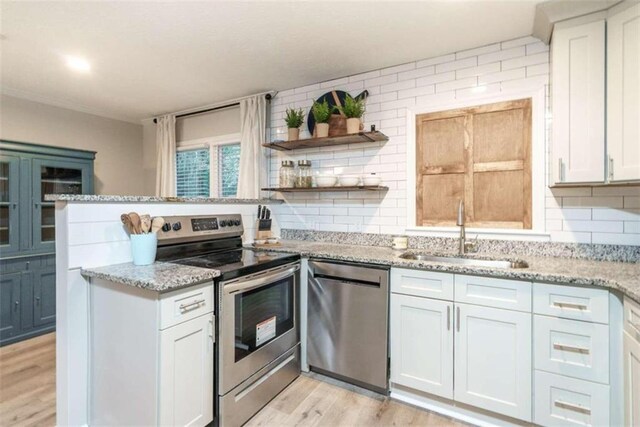 kitchen featuring backsplash, sink, white cabinetry, and stainless steel appliances