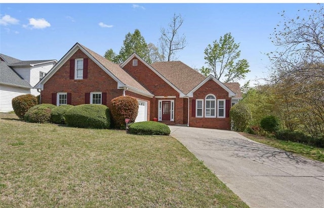 view of front of house with a front yard, concrete driveway, brick siding, and an attached garage