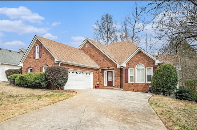 view of front of house with driveway, roof with shingles, an attached garage, a front lawn, and brick siding