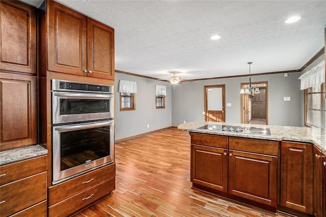 1791 Lake George Dr, Lithia Springs, GA 30122 - kitchen with black electric cooktop, double oven, ornamental molding, light wood finished floors, and a peninsula