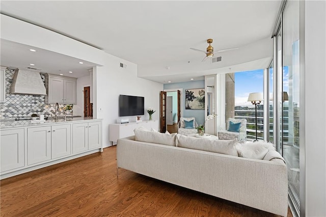 living room featuring a ceiling fan, dark wood-type flooring, and visible vents