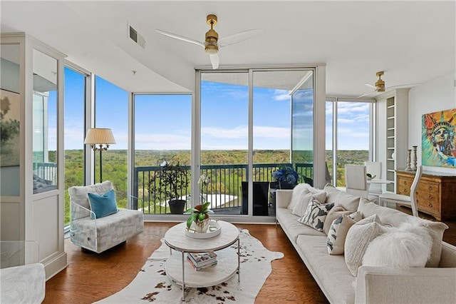 sunroom with visible vents, wood finished floors, and expansive windows