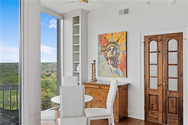 sitting room featuring a ceiling fan, visible vents, and wood finished floors