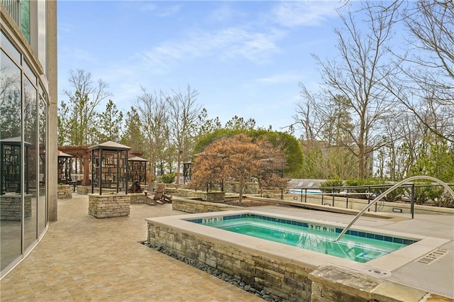 view of pool featuring a hot tub and a patio