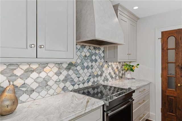 kitchen featuring decorative backsplash, stainless steel electric range, light stone countertops, and custom exhaust hood
