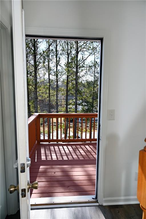 doorway with lofted ceiling, plenty of natural light, and dark hardwood / wood-style floors