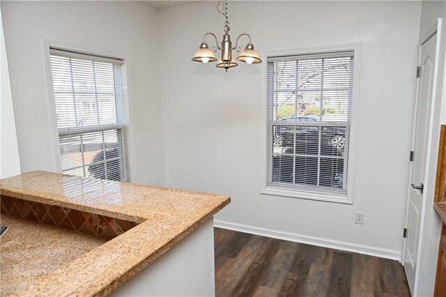 kitchen with dark wood-type flooring, light stone counters, stainless steel refrigerator, kitchen peninsula, and ceiling fan