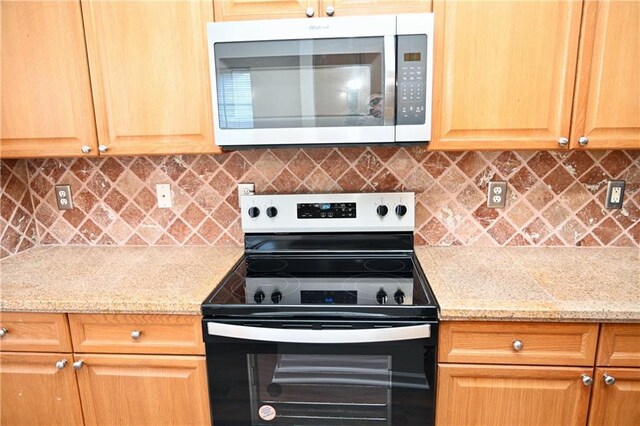 kitchen featuring dark wood-type flooring, ceiling fan, a skylight, stainless steel appliances, and tasteful backsplash