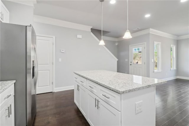 kitchen featuring white cabinetry, hanging light fixtures, stainless steel fridge, a kitchen island, and light stone countertops