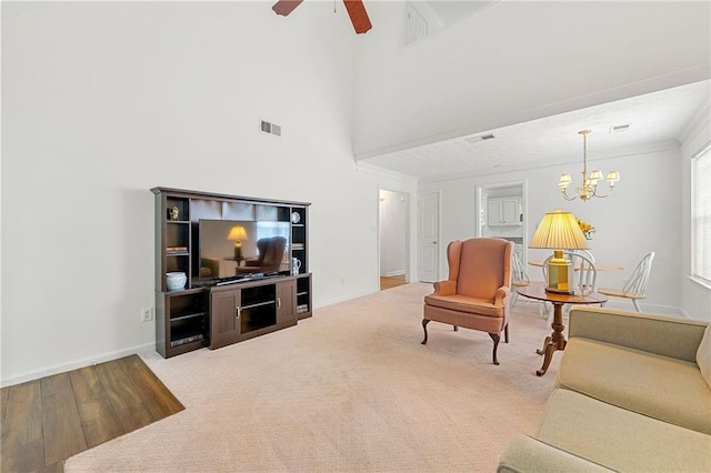 3040 Majestic Park Ct, Duluth, GA 30096 - carpeted living area with a chandelier, a ceiling fan, baseboards, a towering ceiling, and wood finished floors