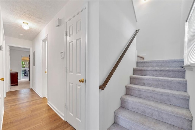 3040 Majestic Park Ct, Duluth, GA 30096 - staircase featuring wood finished floors, a textured ceiling, and baseboards