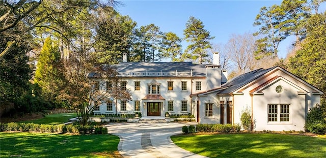 view of front of property with a chimney, driveway, and a front yard