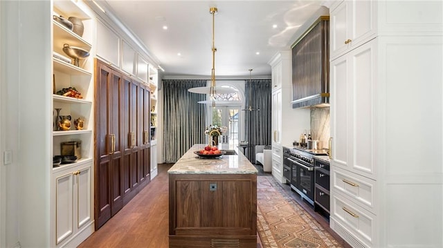 kitchen with range with two ovens, a center island, and white cabinets