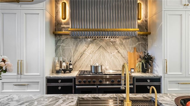 kitchen with tasteful backsplash, extractor fan, double oven range, and white cabinets