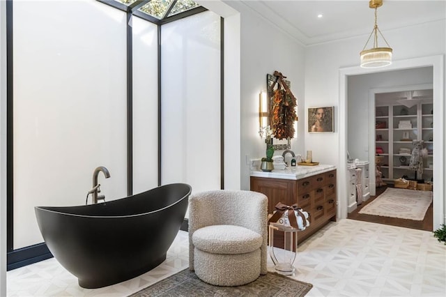 bathroom with crown molding, vanity, and a bathtub