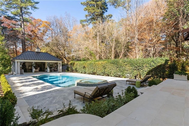 view of swimming pool featuring an in ground hot tub and a patio area