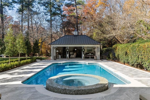 view of pool with an in ground hot tub, an outdoor structure, and a patio area