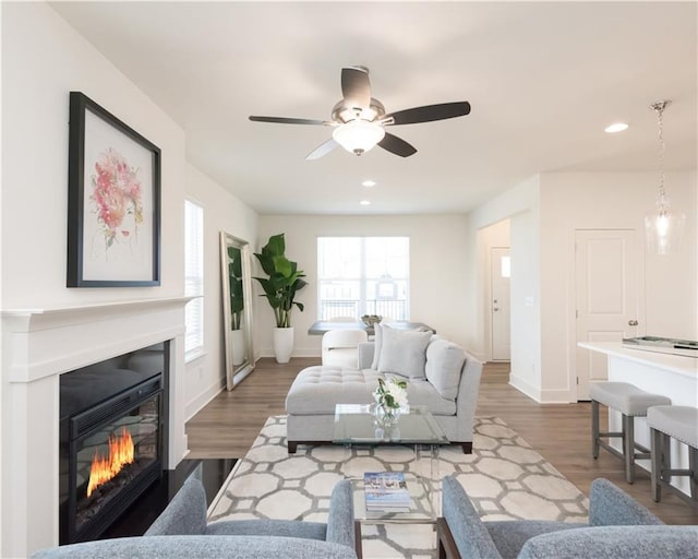 living room with dark wood-type flooring and ceiling fan