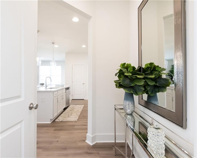 corridor with sink and light hardwood / wood-style floors