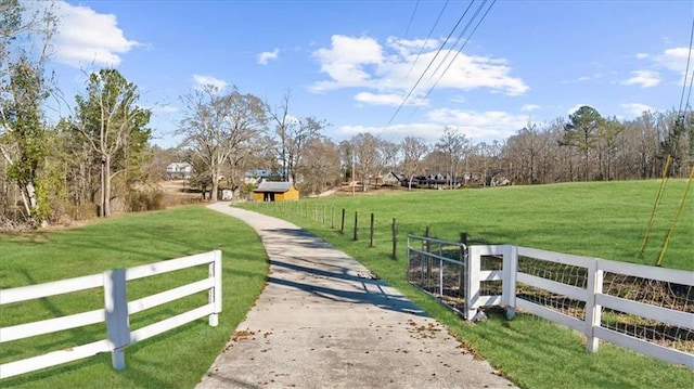 view of gate featuring a rural view and a yard