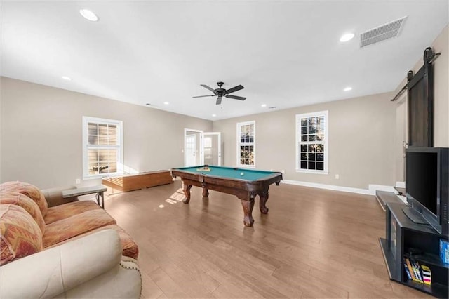 playroom featuring ceiling fan, billiards, light hardwood / wood-style floors, and a barn door