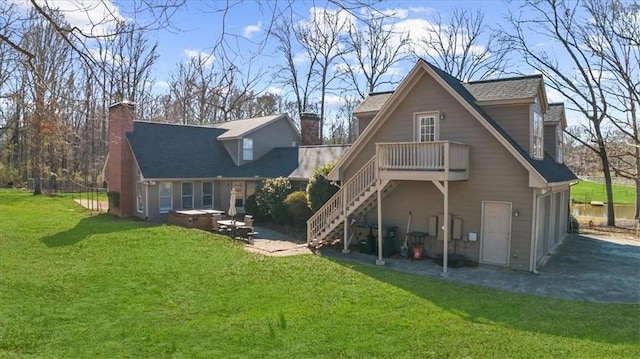 back of property featuring a jacuzzi and a yard