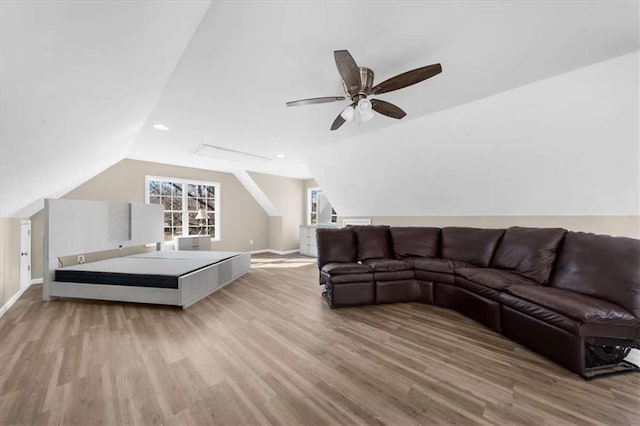 living room with ceiling fan, light hardwood / wood-style flooring, and lofted ceiling