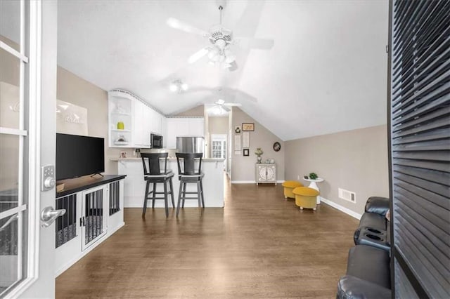 living room with ceiling fan, lofted ceiling, and dark hardwood / wood-style flooring