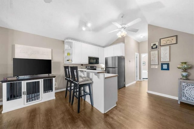 kitchen with a kitchen bar, white cabinetry, stainless steel appliances, dark wood-type flooring, and kitchen peninsula