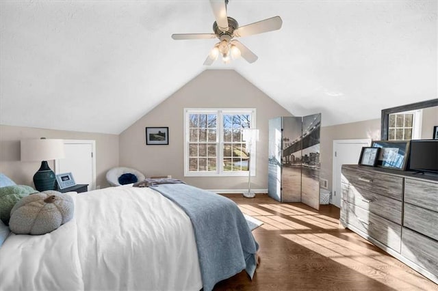 bedroom featuring hardwood / wood-style floors, vaulted ceiling, and ceiling fan