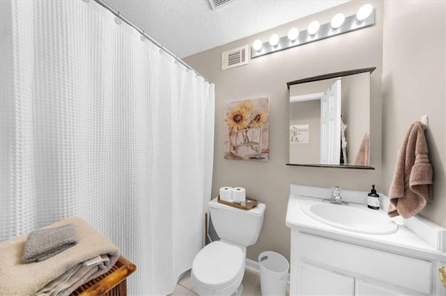 bathroom with a textured ceiling, vanity, toilet, and tile patterned floors