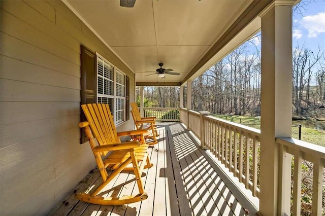 wooden deck featuring covered porch and ceiling fan