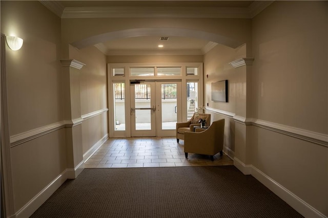 entryway with french doors, ornamental molding, and carpet