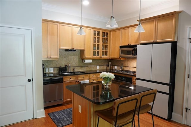 kitchen featuring decorative light fixtures, sink, a breakfast bar area, a center island, and stainless steel appliances