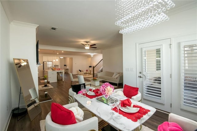 dining area featuring visible vents, a ceiling fan, ornamental molding, stairway, and dark wood-style floors