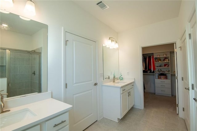 full bath with two vanities, visible vents, a sink, and a shower stall